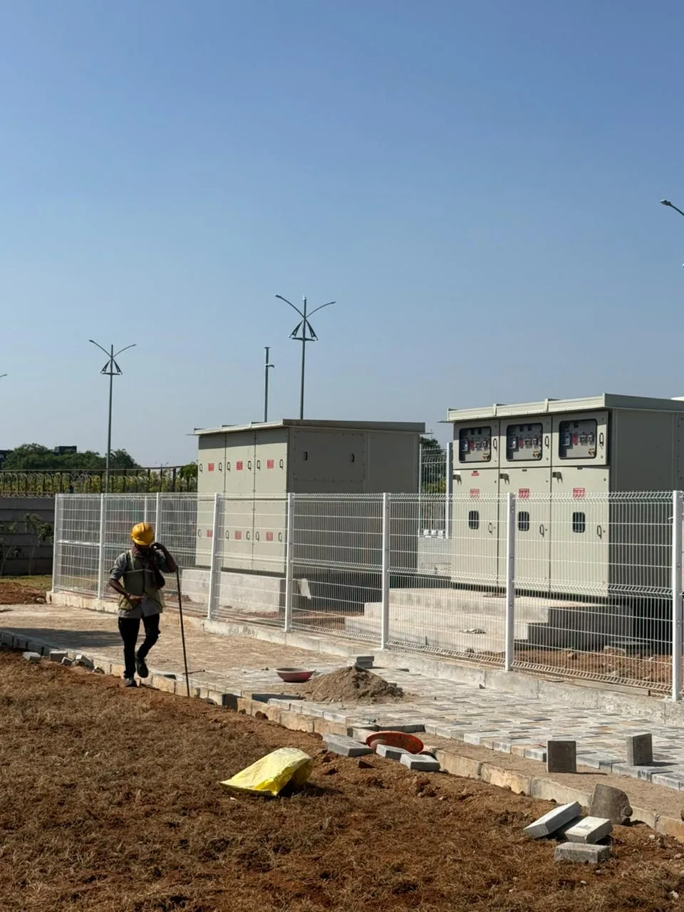 Nexus Fence H-section posts being installed on a construction site with welded mesh panels