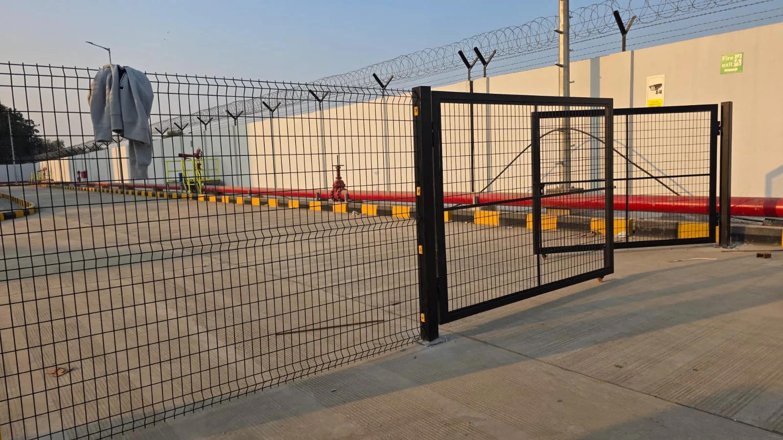 Nexus Indus-Shield swing gate and yellow welded mesh fence securing an airside compound at SVPIA Ahmedabad