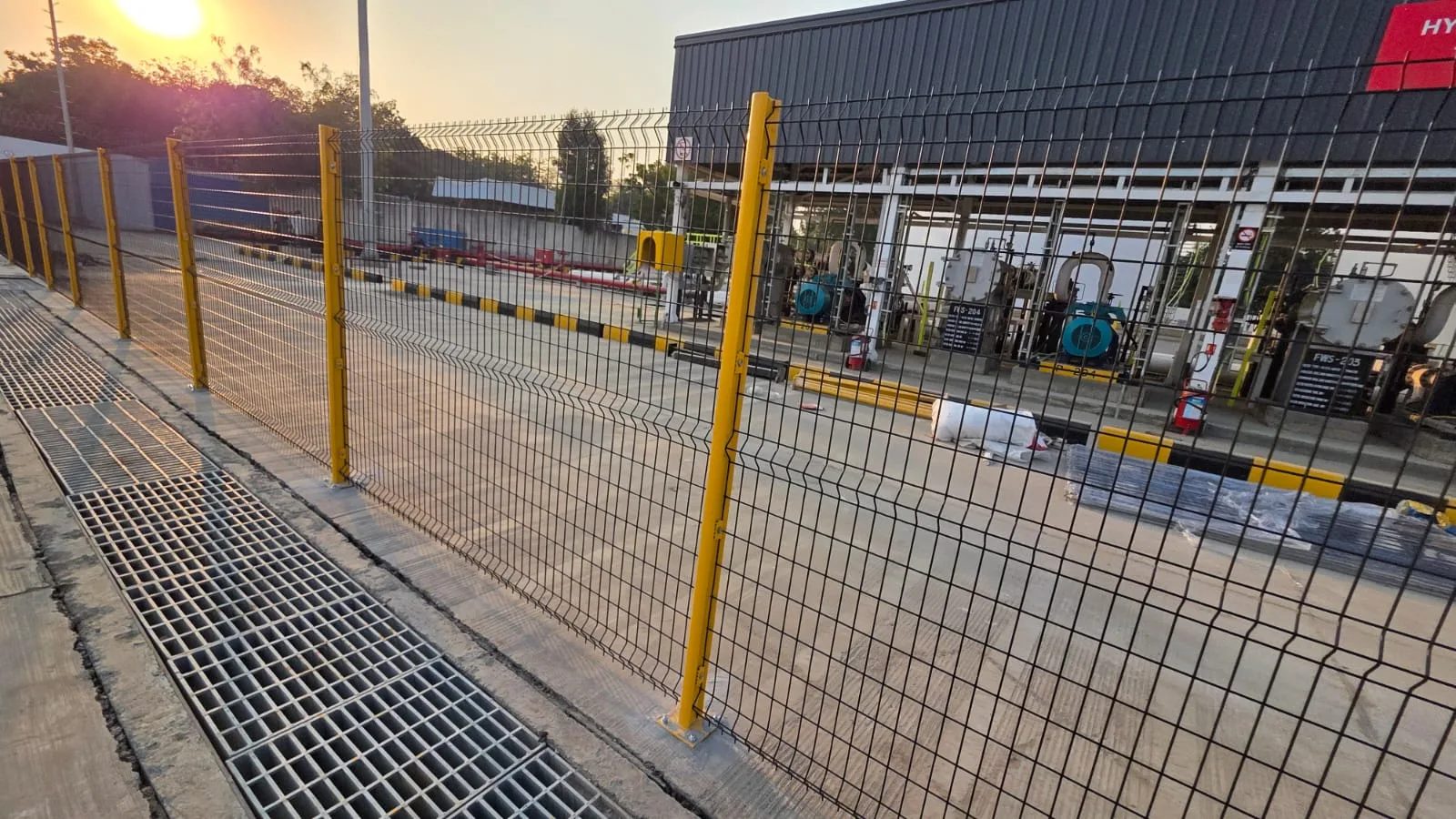 Nexus Indus-Shield yellow fencing beside a drainage grate on the airside at SVPIA Ahmedabad